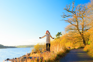 Obraz premium Autumn, Woman walking relaxing at the river. Co.Cork, Ireland.