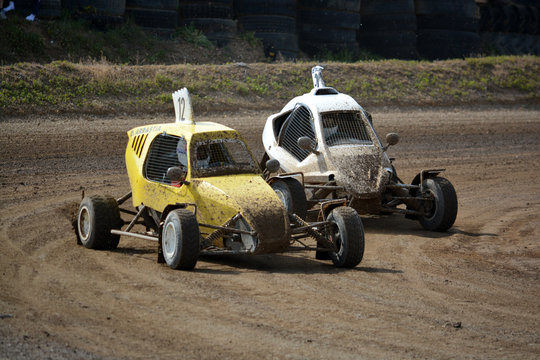 dos buggies adelantandose en una curva de carrera