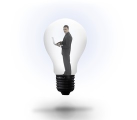 Businessman holding laptop in light bulb