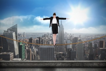 Fototapeta na wymiar Composite image of businesswoman performing a balancing act