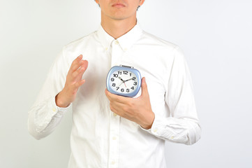 目覚まし時計を持っている男性