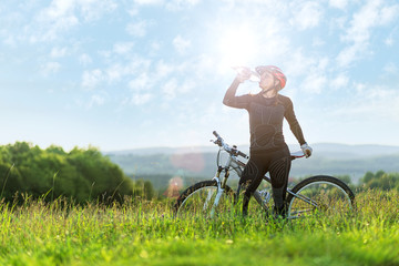  Sport bike woman , drinking on a meadow , beautiful landscape
