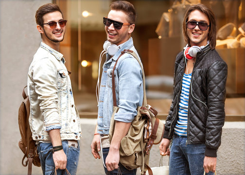 Fashion young guys go shopping with many colored shopping bags