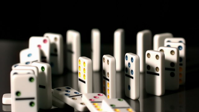 Finger pushing over colourful dominoes