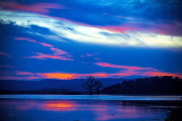 Fototapeta na wymiar Dramatischer Sonnenuntergang an einem See