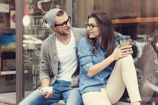 Young People Relaxing With Cup Of Coffee Outside The Cafe