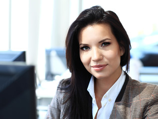 Casual businesswoman using laptop in office