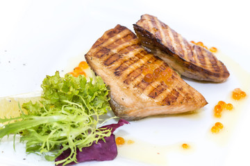 Grilled salmon fillet with vegetables and caviar