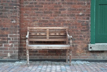 Wooden vintage chair in front of brick wall