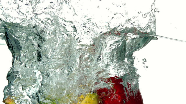 Selection of fruit plunging into water on white background