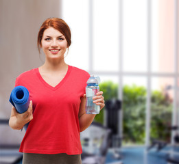smiling girl with bottle of water after exercising