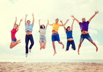 group of friends jumping on the beach