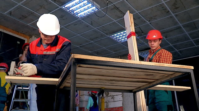 Happy group people  builder with circular saw..