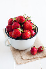 strawberries in white enamel mug