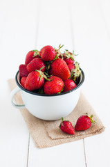strawberries in white enamel mug