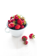 strawberries in white enamel mug