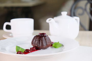 a served table with a muffin, a coffee pot and a cup
