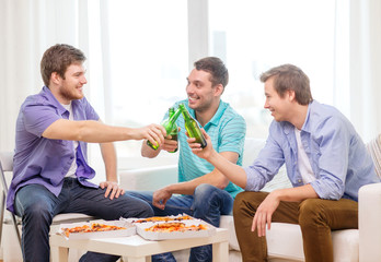 smiling friends with beer and pizza hanging out