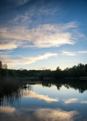 Naklejka na ściany i meble Summer vibrant sunset reflected in calm lake waters