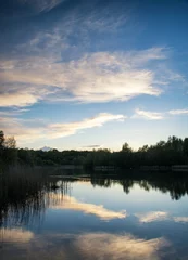 Foto op Canvas Levendige zomerzonsondergang weerspiegeld in kalm meerwater © veneratio