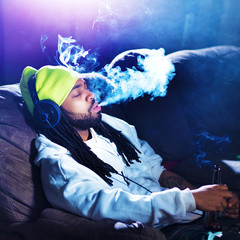cool man smoking marijuana on his couch
