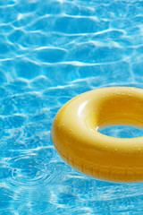 floating ring on blue water swimpool with waves reflecting