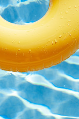 floating ring on blue water swimpool with waves reflecting