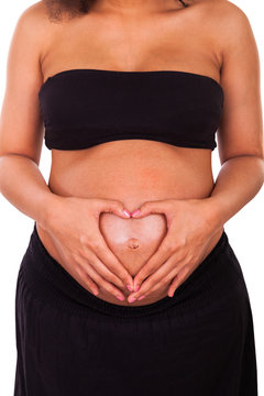 pregnant african american woman hands on belly forming a heart