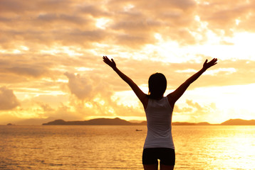 cheering woman  open arms at sunrise seaside