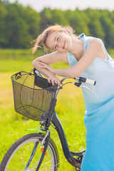 Happy Smiling Caucasian Blond With Bicycle in the Park