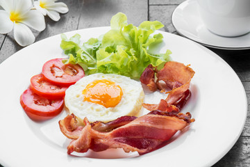 Breakfast with fried egg, bacon and coffee cup