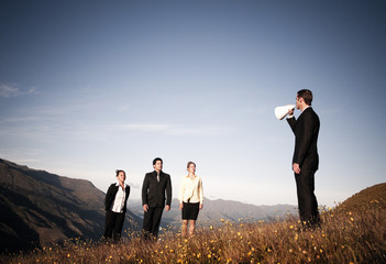 Businessman Speaking Through Paper Megaphone To Business People