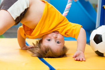 baby standing upside down on gym mat