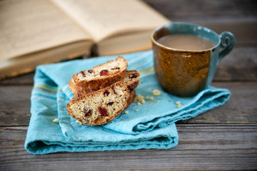 Biscotti cookies with a cup of coffee and a book