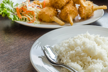 Fried shrimp ball on sugarcane skewers and plate of rice