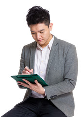 Businessman making note on clipboard