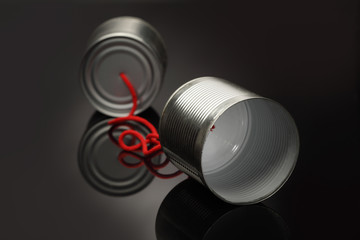 phone toy from a tin can lying on a smooth black polished table