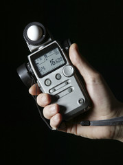 Lightmeter in hands isolated on black