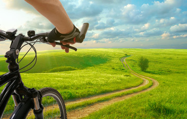 Man with bicycle riding country road