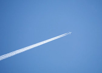 Large passenger jet flying in clear sky, leaving white trail