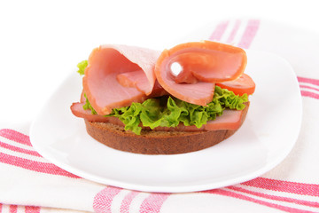 Delicious sandwiches with lettuce and ham on plate close-up