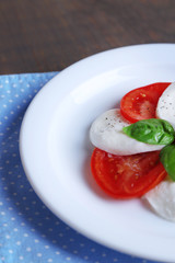 Caprese salad with mozarella cheese, tomatoes and basil