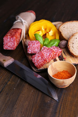 Composition with knife,  tasty salami sausage, sliced bread and