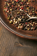 Spice pepper in spoon on wooden background