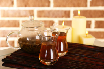 Composition with tea in cup and teapot and candles