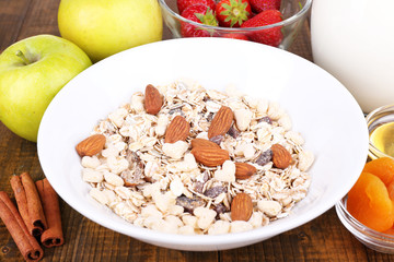 Healthy cereal with milk and fruits on wooden table