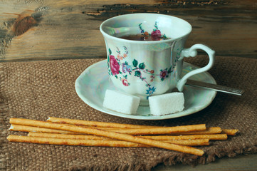 cup of tea, sugar and bread sticks