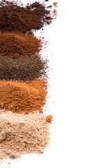 Cocoa powder, dried tea leaves and grounded coffee over white 