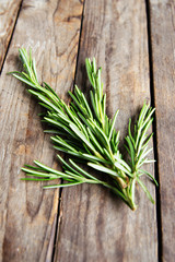 fresh rosemary bunch on an old rustic wooden table - obrazy, fototapety, plakaty