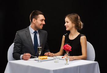 smiling couple eating dessert at restaurant